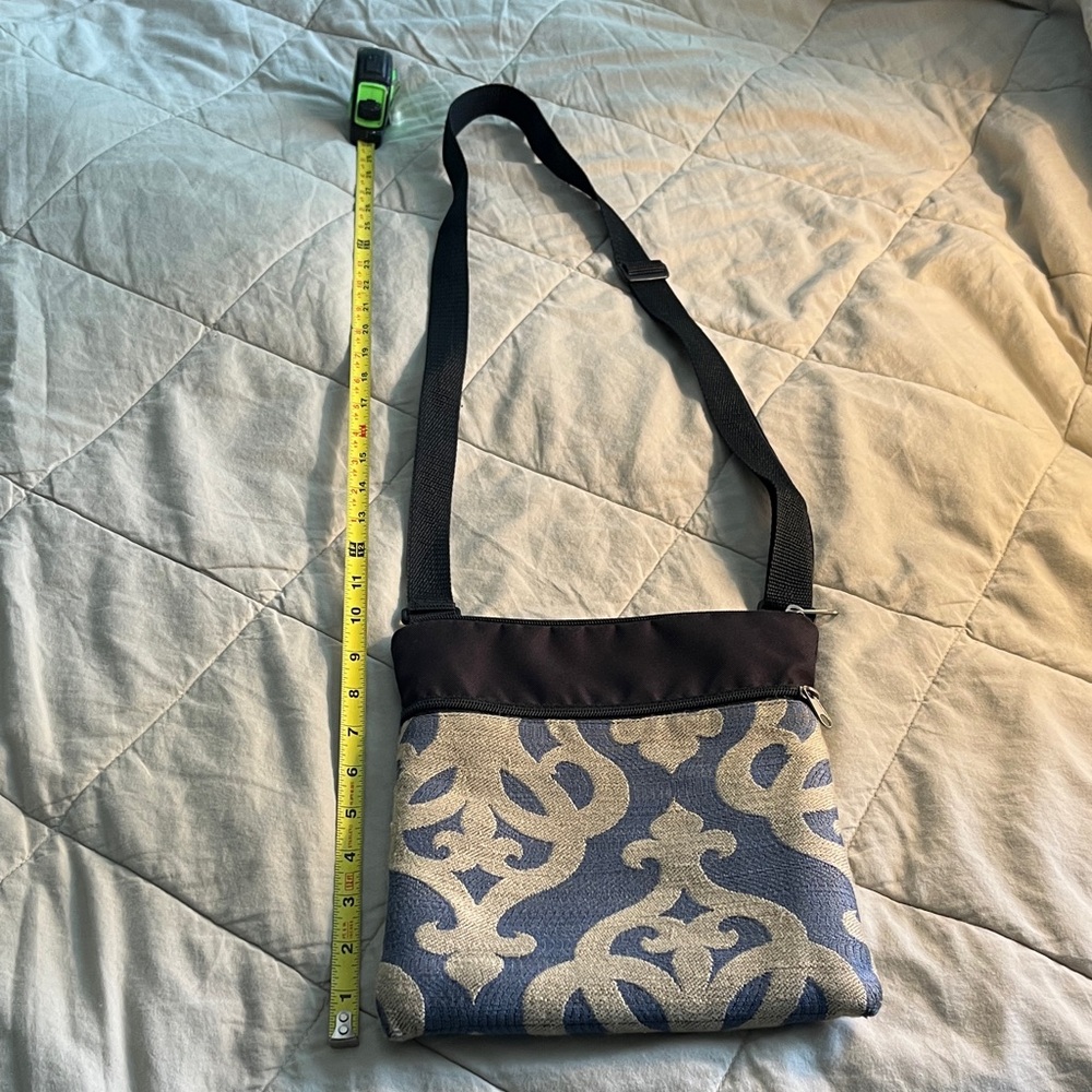 Blue and tan tapestry pattern crossbody bag with black strap and top